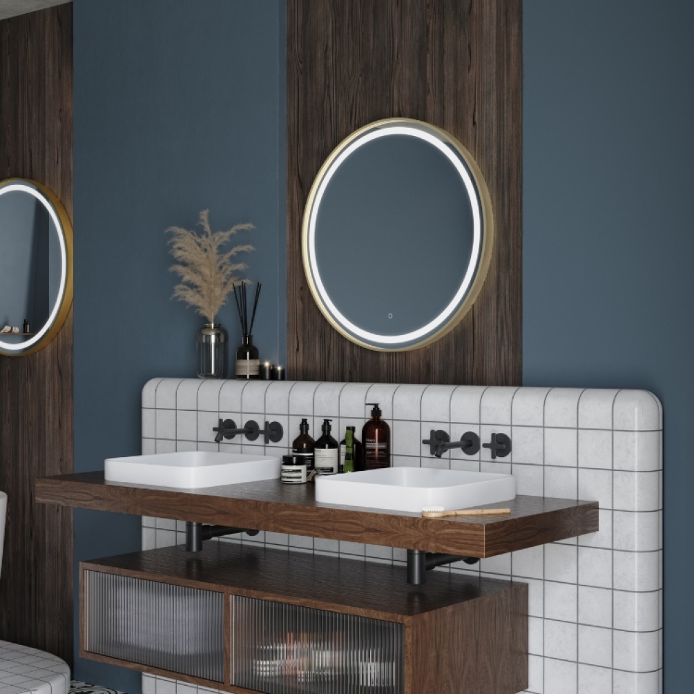 Product Lifestyle image of Origins Living Lomax Light 700mm x 700mm Brushed Brass Round Mirror mounted on a wall, in-front of a dual basin. LML-01D070-BB